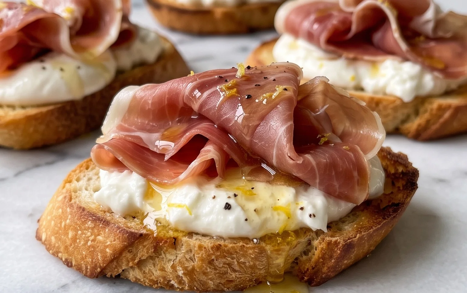 Beef Prosciutto Crostini with Burrata and Lemon Honey Drizzle